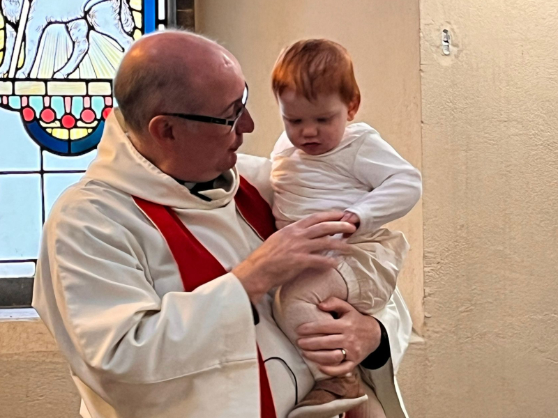 Rev David baptises a child at St Luke's.